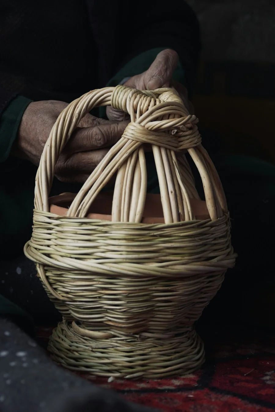 Hands shaping the framework of a woven basket