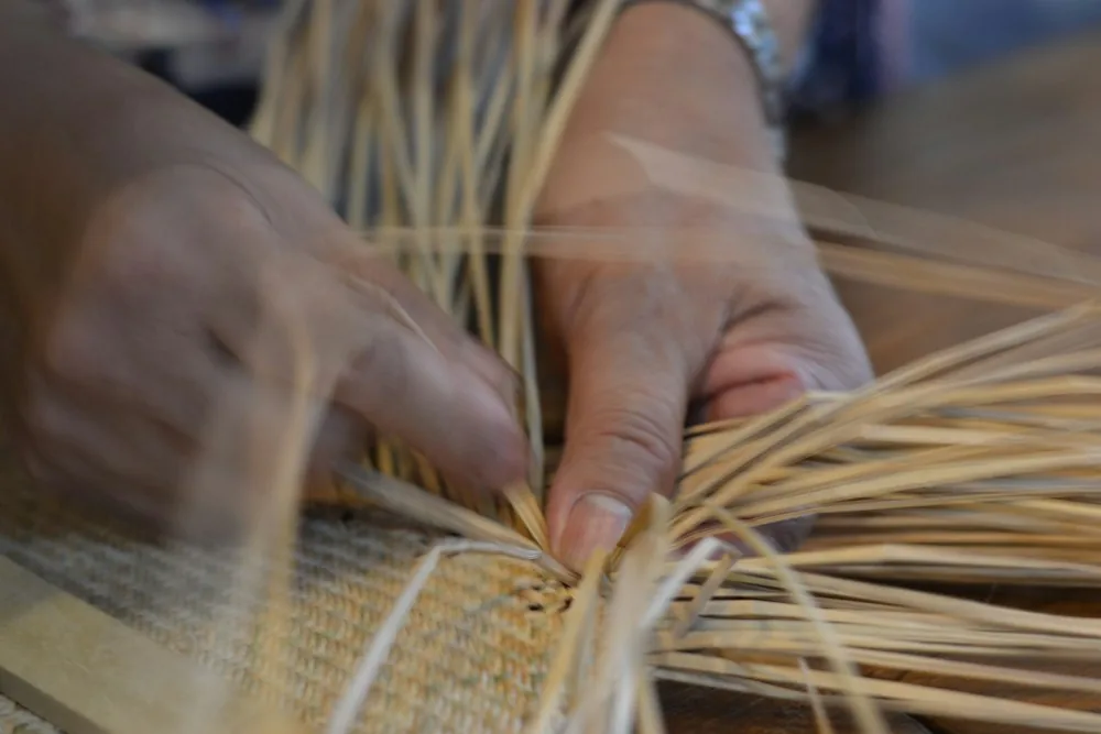 Artisan hands weaving natural fibre strands