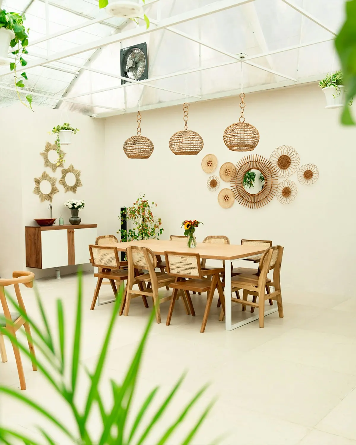 Bright dining room with rattan wall mirrors and woven pendant lamps