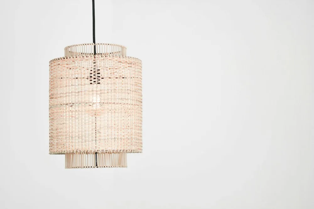 Cylindrical rattan pendant lampshade on a white background
