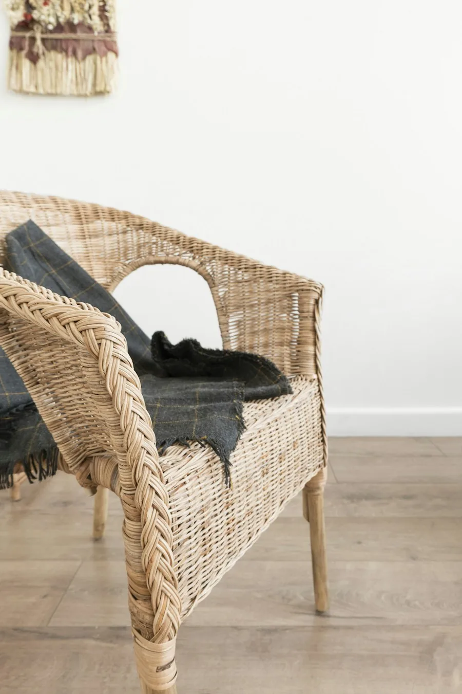 Natural wicker armchair against a white wall