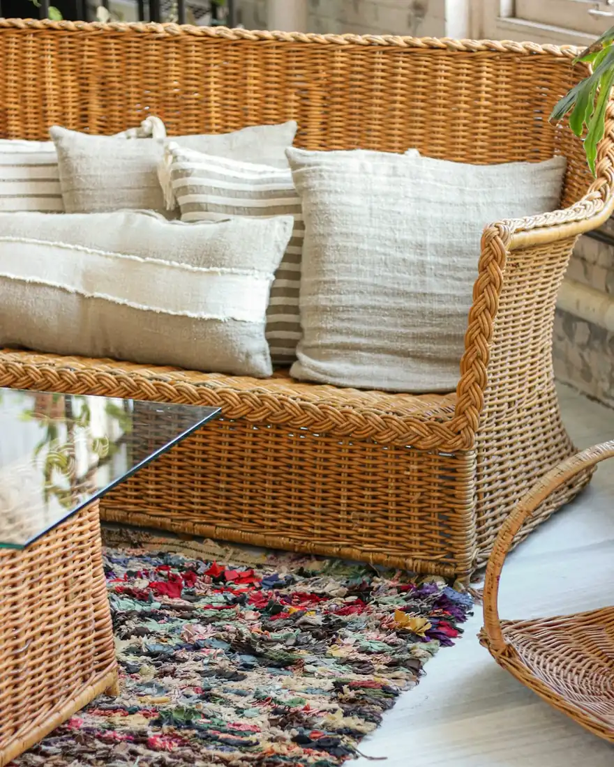 Wicker-framed glass-top coffee table beside a wicker sofa